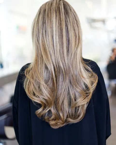 Lange, gewellte Haare von hinten mit weichen Blond- und Honigtönen.