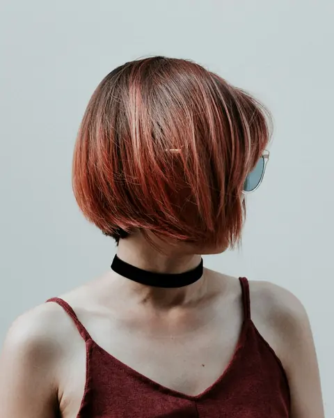 Asymmetrischer Bob in Rotkupfer, der Kopf ist abgewandt, am Hals ein schwarzes Halsband.